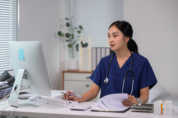 Asian medical professional managing patient data on computer