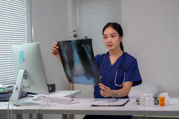 Female doctor analyzing patient chest x-ray scan in clinic