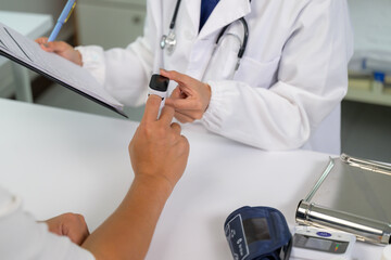 Doctor measuring patient oxygen saturation and recording data