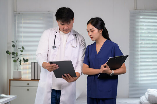 Doctors and nurse analyzing patient data on digital tablet