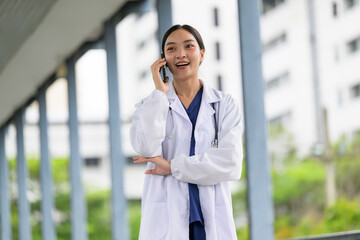 Asian female doctor having phone call walking in hospital
