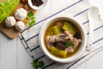 Bitter gourd soup with pork baby back spare rib or pork cartilage in white bowl.Top view copy space.
