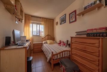 Teen bedroom with a trundle bed, a small sofa, and a gaming computer desk