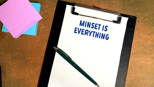 The concept of writing MINSET IS EVERYTHING on a notebook isolated on a beautiful work desk.
