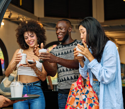 Portrait of group of young people drinking coffee in coffee shop city street, walking together and having fun.