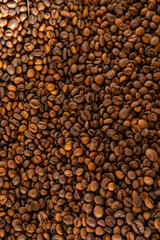 Close-up pile of roasted coffee beans with rich brown tones and textured surface, emphasizing freshness, quality, and aromatic appeal.