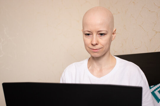 Serious woman with no hair studying online, e-learning education from home, student using laptop for distance learning - Powered by Adobe