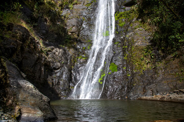 A beautiful mountain waterfall. The water falls into a lake. The waterfall is in Bolivia.