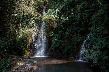 A beautiful mountain waterfall. The water falls into a lake. The waterfall is in Bolivia.