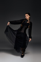 Girl in gothic dress channels Wednesday character for spooky Halloween fun