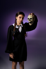 Girl in gothic style dress with braids embraces Halloween spirit as Wednesday character