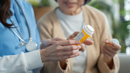 Nurse or caregiver assisting elderly woman with medication instructions during home visit or Nursing home.female nurse helping a senior woman.medication,home healthcare,medication guidance concept
