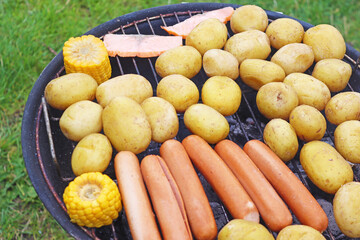 View on the grill with vegetables and sausages, fish