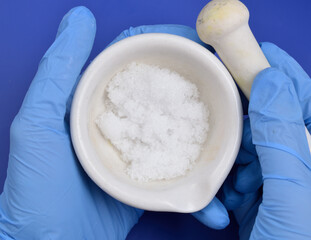 Magnesium nitrate powder on light grey background.