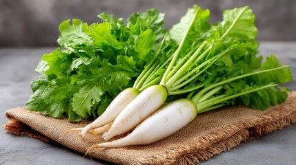 Daikon radish with green leaves on burlap cloth
