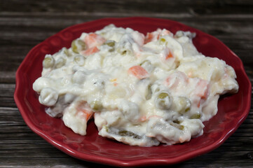 The simple Russian salad, Olivier salad, features potatoes, carrots and peas coated in a creamy mayonnaise dressing, all vegetables are cooked until tender but not mushy, then mixed together