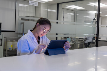 Scientist working in a lab using a tablet for research during the day