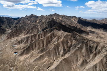 Aerial View of the Austere Northwest: Mountain Ridges Etched Against the Vast Gobi Desert​