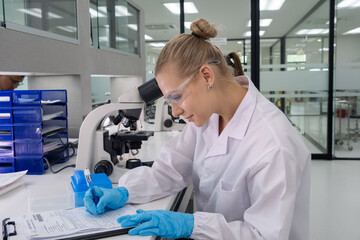 Scientist performs laboratory work while analyzing samples and recording data in a modern lab setting