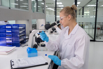 Scientist conducting research in a modern laboratory during daytime hours with equipment and paperwork