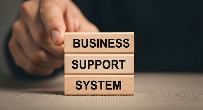 Hand arranging wooden blocks spelling out business support system