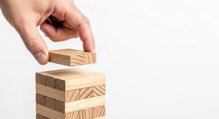 Economic recession, A hand carefully places a wooden block on top of a stacked tower