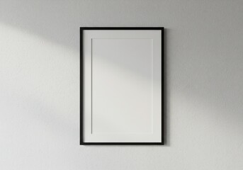 Sleek Vertical Black Frame Mockup on a Textured White Wall with Soft Diagonal Light.
