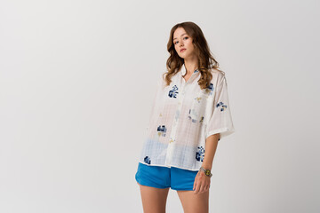 Young woman confidently showcases fashionable summer attire in a bright and airy setting © LIGHTFIELD STUDIOS