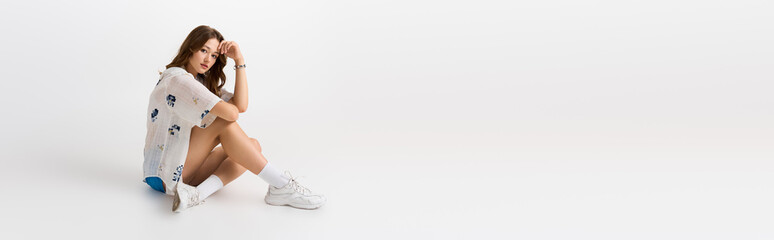 Young fashionable woman exudes confidence in stylish attire during vibrant indoor session