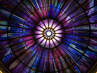 Circular stained glass ceiling with purple and blue hues