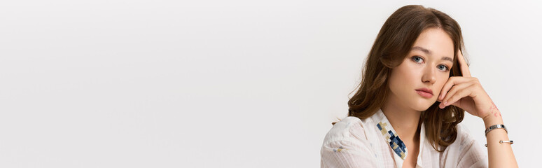 Fototapeta premium Young fashionable woman showcasing modern style and elegance in a dynamic pose