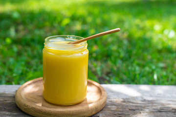 Ghee in a jar in a meadow. Selective focus.
