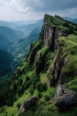 Fototapeta premium Green mountain cliff overlooking dramatic valley landscape