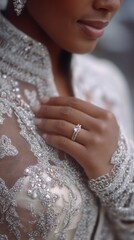 Close-up portrait of a woman in a formal, embroidered dress, hand near her face, displaying a ring