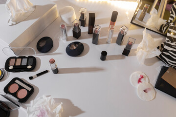 Makeup Station, Counter after client who choosing lipstick and other cosmetics. Used cotton pads, facial tissue, wipes, blushes, powder foundation on white desk
