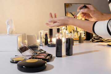 Woman applying soft pink lipstick on her wrist near the makeup counter at the beauty store. Compare colors and choosing right lipstick for her outfit