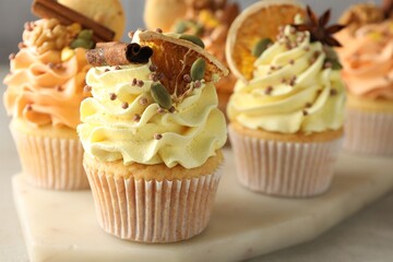 Delicious cupcakes with colorful cream and spices on grey table, closeup