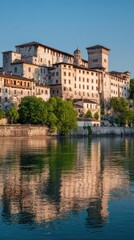 Fototapeta premium Old European town with stone buildings by a river reflecting in the water at twilight