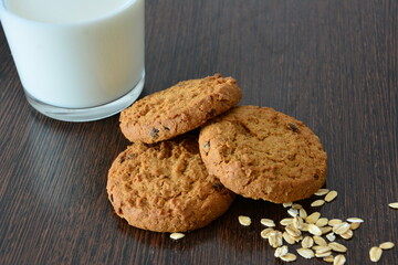 american cookies and milk on a wooden surface with some oat flakes