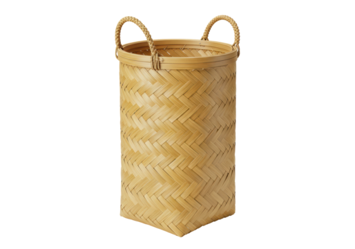 Isolated woven bamboo basket with handles stands upright on a surface in a studio setting