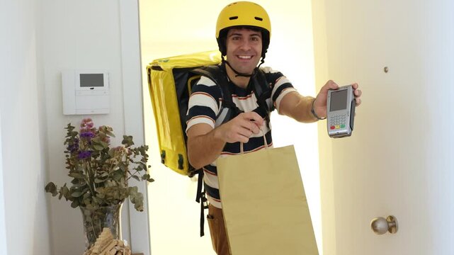 Delivery man with thermal backpack holding credit card reader terminal