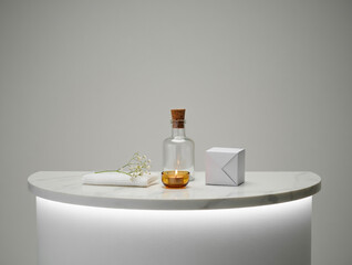 White marble surface with spa items and lit candle
