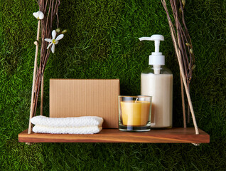 Wooden shelf with spa items on moss background wellness