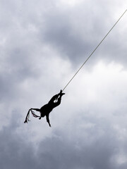 Silhouette of a Papantla flyer descending mid-air during the traditional "Danza de los Voladores." This ritual performance is an important part of Mexico's indigenous heritage.