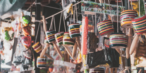 Colorful traditional Mexican toys and crafts hanging in a market stall, showcasing vibrant local culture and handmade artistry.
