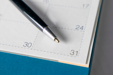 Black business pen on calendar background. Appointment planning work schedule.