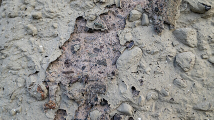 Damaged concrete wall texture with stones
