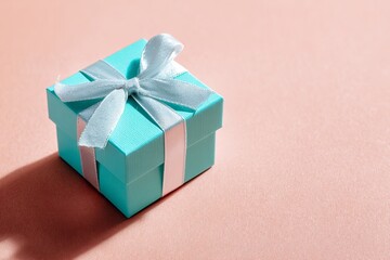 Obraz premium Elegant turquoise gift box with satin ribbon, a symbol of surprise and luxury, perfect for special occasions and cherished moments, evoking joy and anticipation