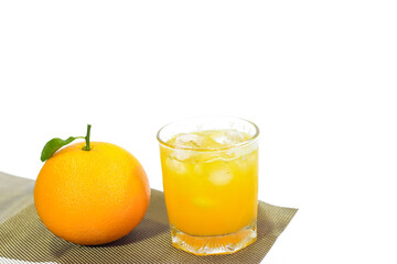 Glass of Valencia Orange Juice with a Whole Orange on a Placemat, White Background