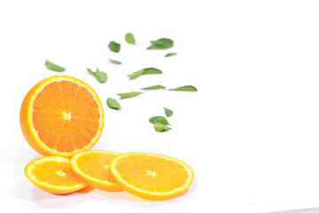 Whole and Sliced Valencia Orange with Leaves on a White Background